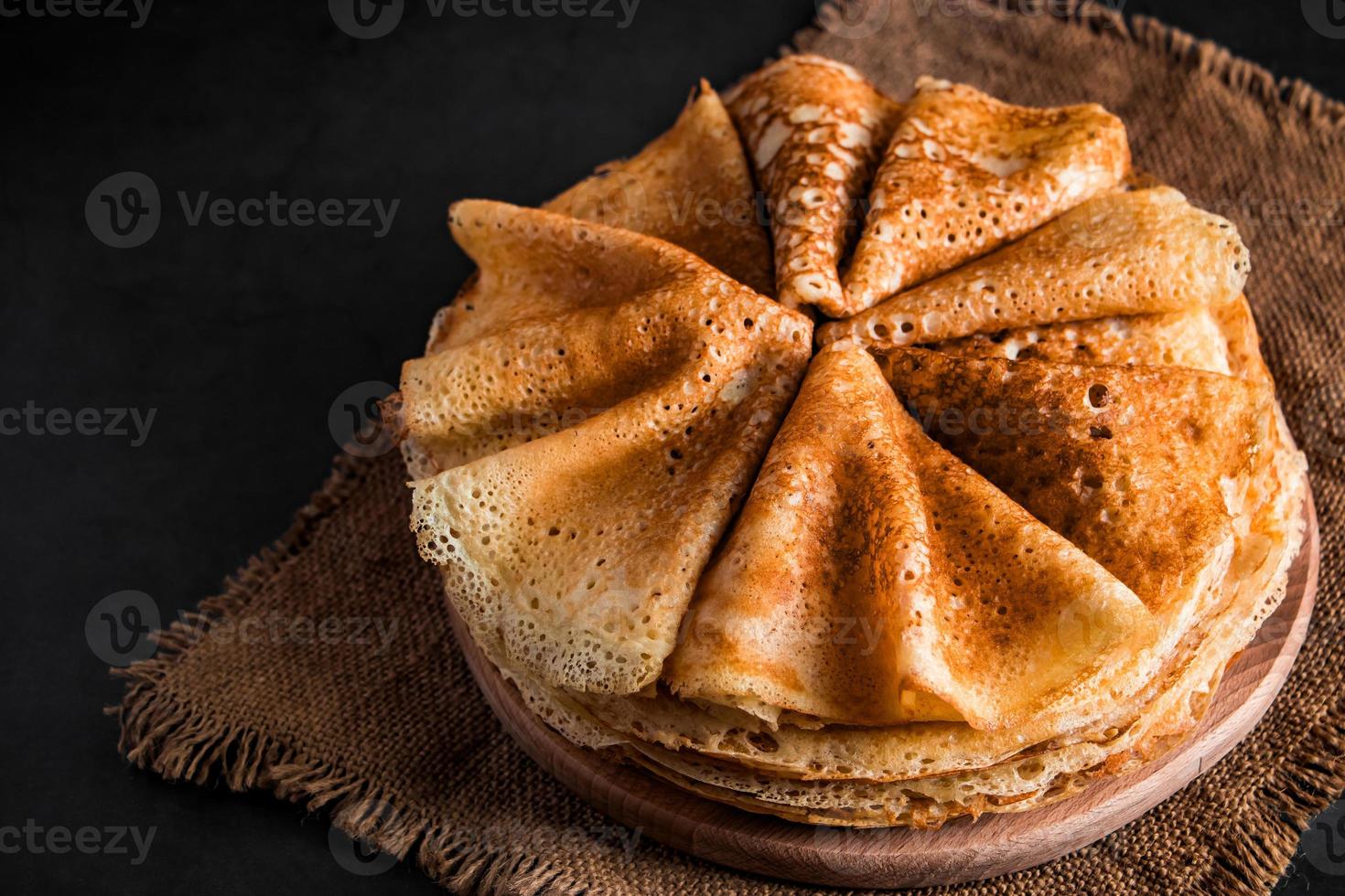 stapel heerlijke pannenkoeken op een zwarte achtergrond foto