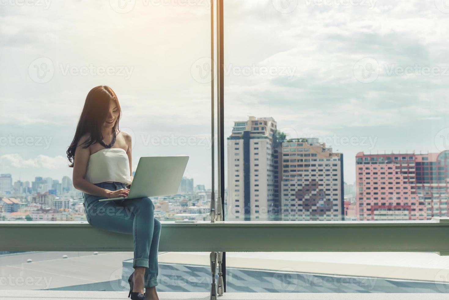 vrouw met behulp van een laptop computer met city scape achtergrond foto