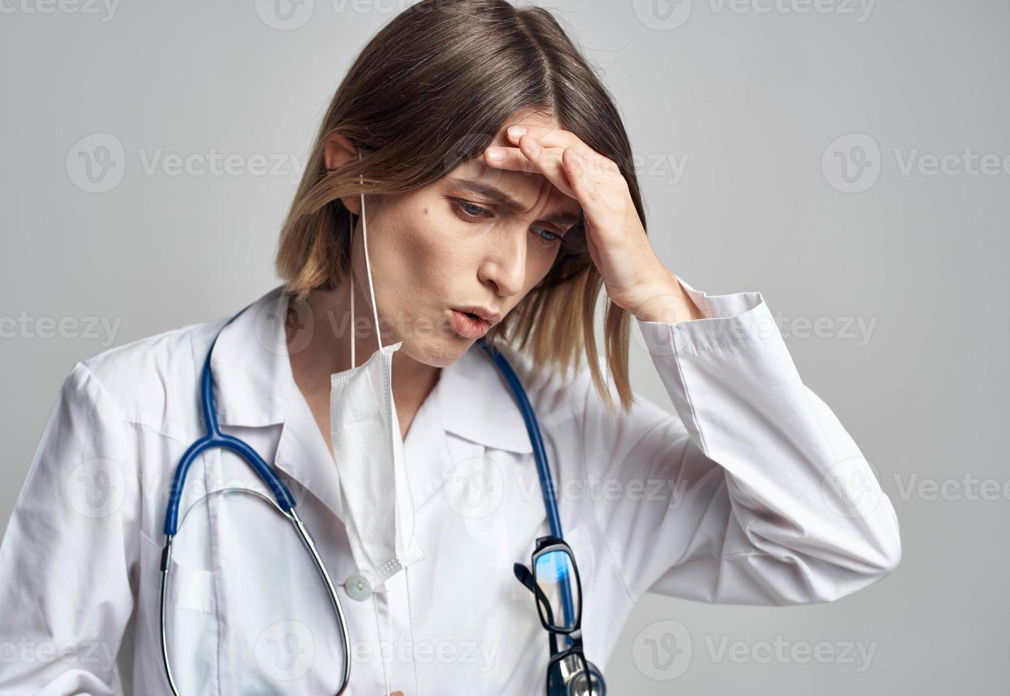 dokter professioneel met een stethoscoop en in een medisch japon Aan een licht achtergrond medisch masker foto