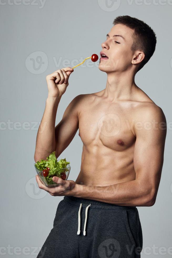 atletisch vent met een opgewonden torso gezond voedsel salade bord maaltijd training foto