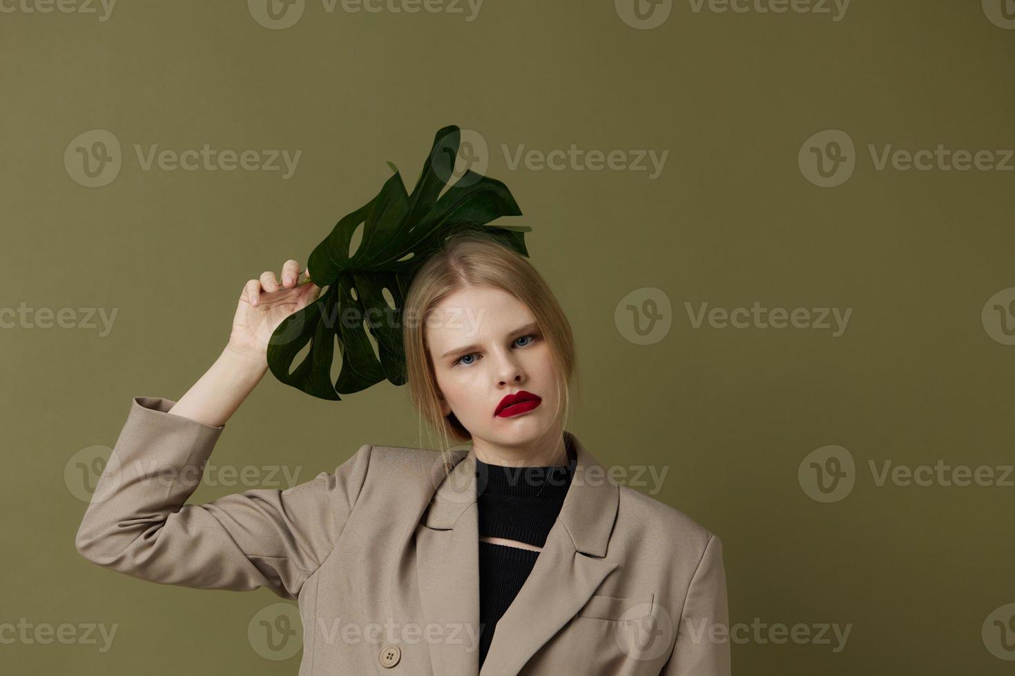 portret van een vrouw rood lippen palm blad charme mode geïsoleerd achtergrond foto