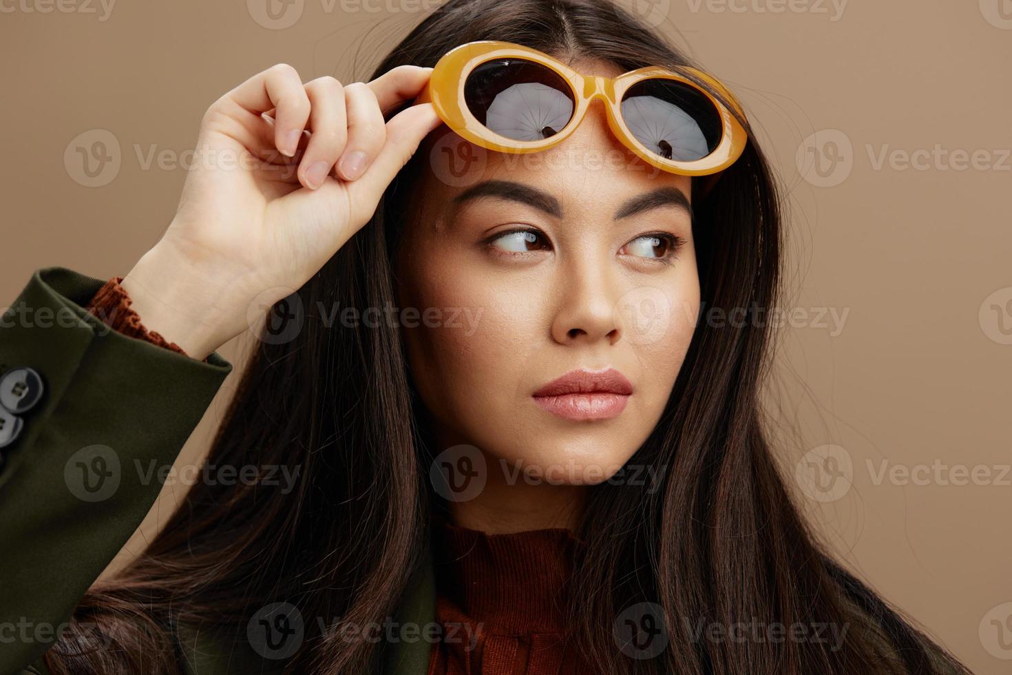 vrouw jasje zonnebril elegant stijl mode beige achtergrond foto