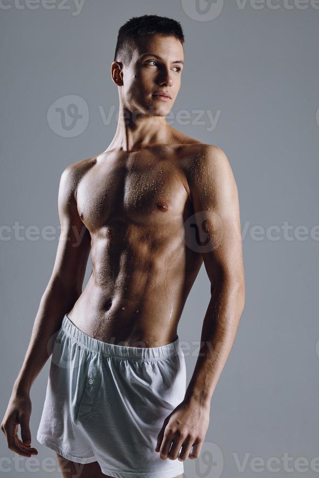 sterk mannetje atleet met gebogen arm spieren Aan grijs achtergrond bijgesneden visie foto
