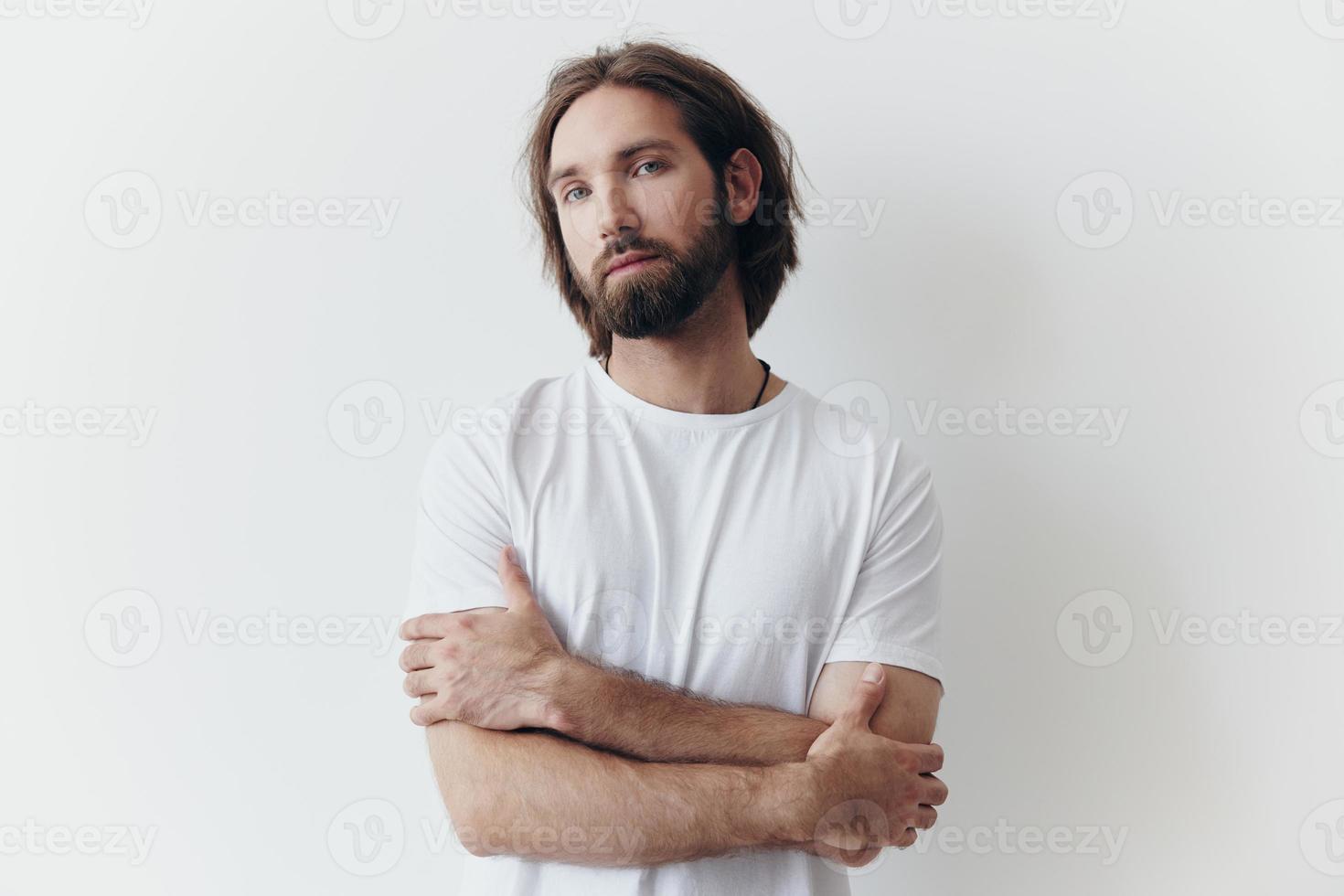 portret van een Mens met een zwart dik baard en lang haar- in een wit t-shirt Aan een wit geïsoleerd achtergrond levensstijl zonder pathos elke dag beeld foto