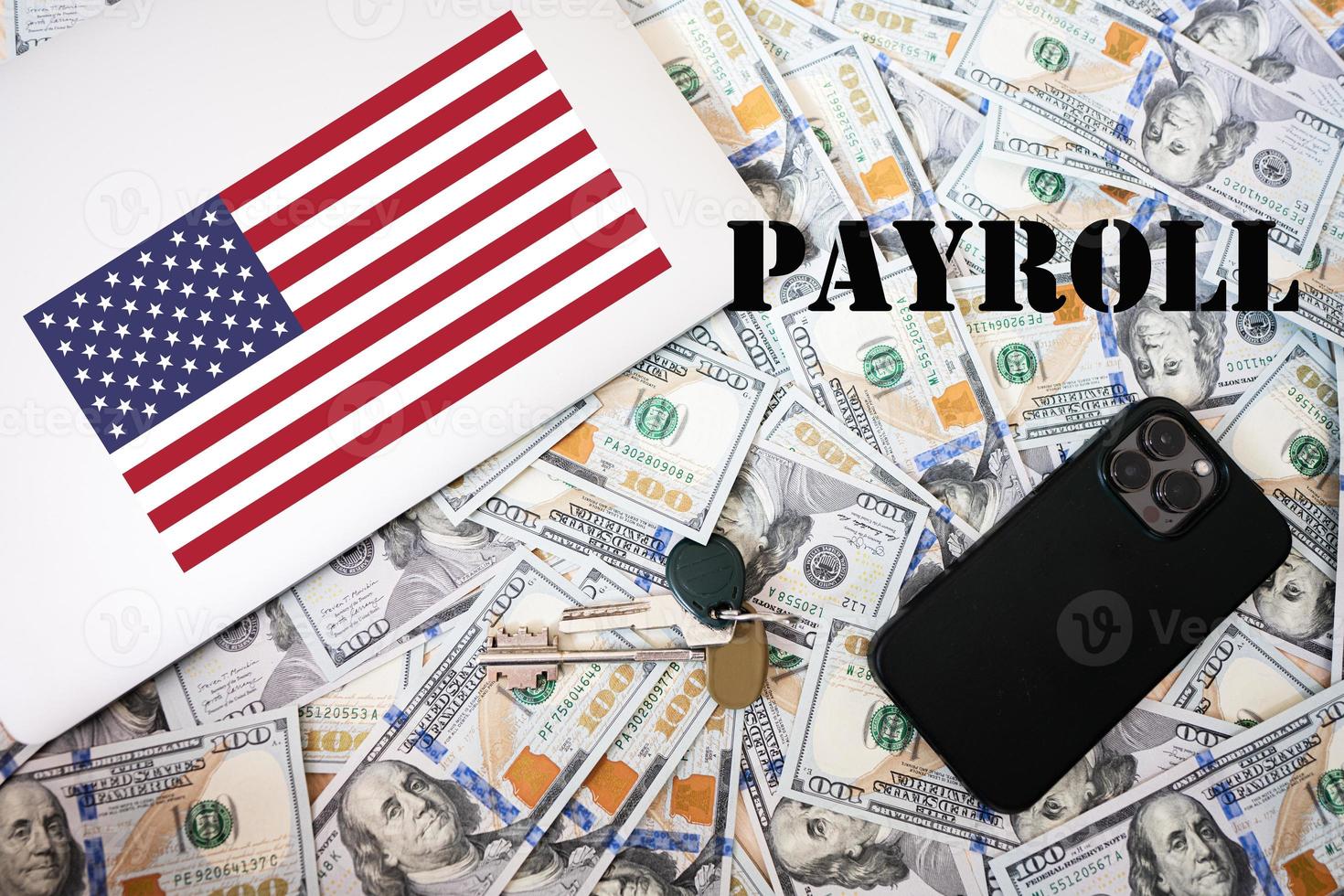 loonlijst concept. Verenigde Staten van Amerika vlag, dollar geld met sleutels, laptop en telefoon achtergrond. foto