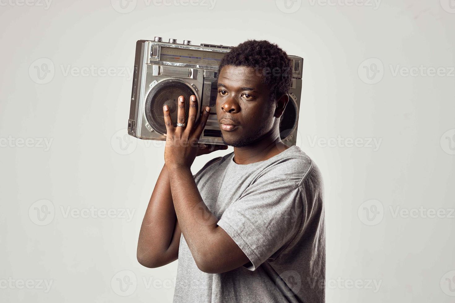 Mens met een plakband opnemer in zijn handen luisteren naar muziek- Afrikaanse uiterlijk levensstijl foto
