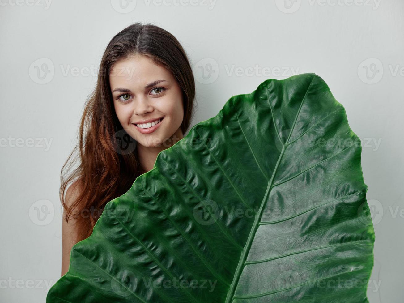 roodharig vrouw palm blad glimlach detailopname bijgesneden visie foto