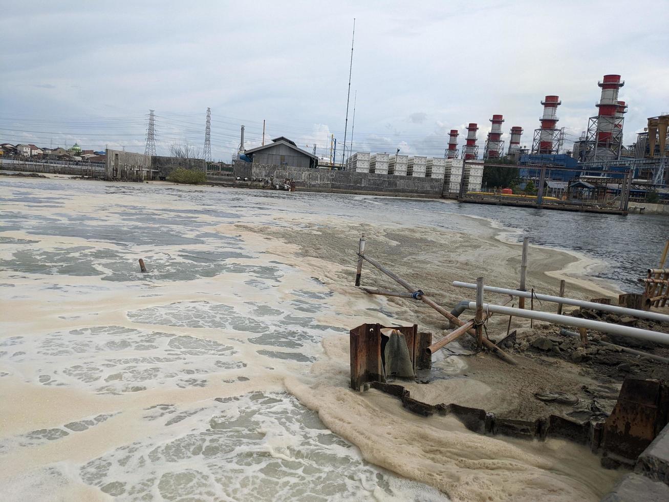 schuimend zee water Aan de uitval steenkool ontslagen macht fabriek. de foto is geschikt naar gebruik voor verspilling water poster, macht fabriek werkzaamheid en milieu inhoud media.