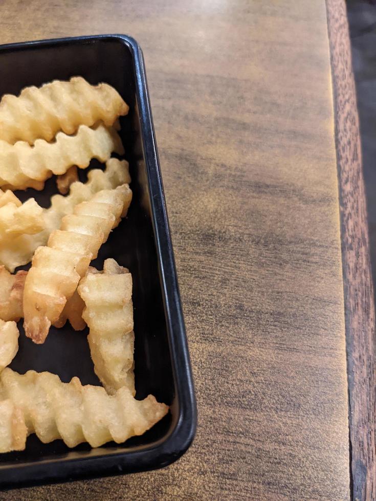 dichtbij omhoog gebakken Patat met houten tafel Aan de restaurant. de foto is geschikt naar gebruik voor traditioneel voedsel achtergrond, poster en voedsel inhoud.