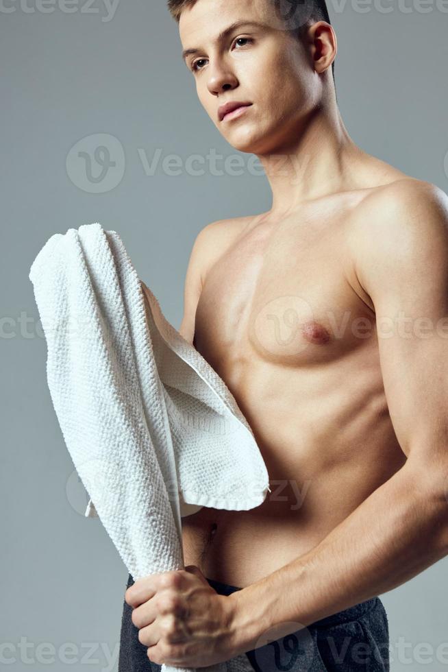 portret van een sport- vent naakt torso handdoek in hand- poseren foto