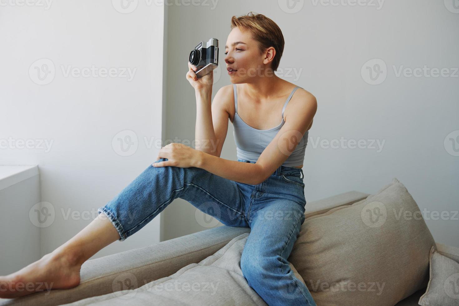 vrouw fotograaf het schieten in studio Aan oud film camera Bij huis Aan bankstel portret, wit achtergrond, vrij kopiëren ruimte, freelance fotograaf foto