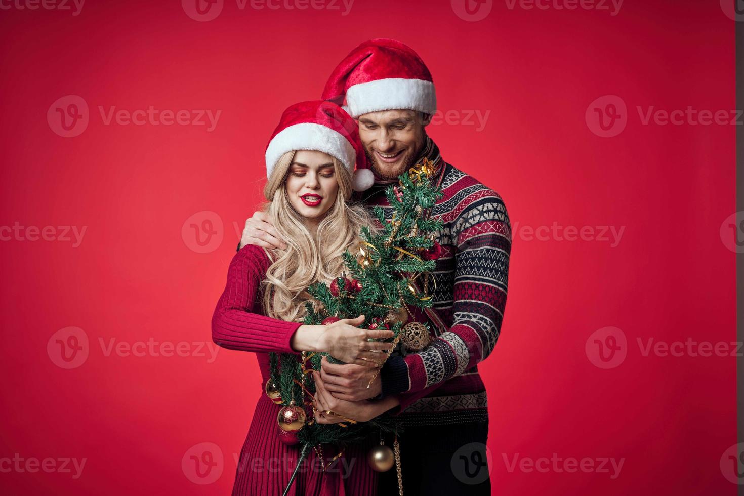 vrolijk getrouwd paar vieren Kerstmis nieuw jaar rood achtergrond foto