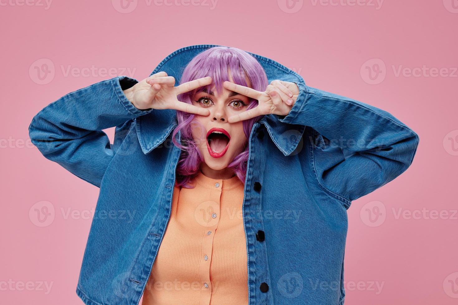 schoonheid mode vrouw Purper kapsel rood lippen denim jasje pret roze achtergrond ongewijzigd foto