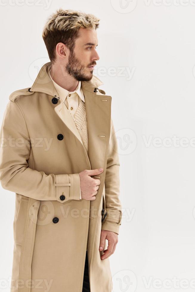 Mens met modieus kapsel in beige jas modern stijl herfst kleding foto