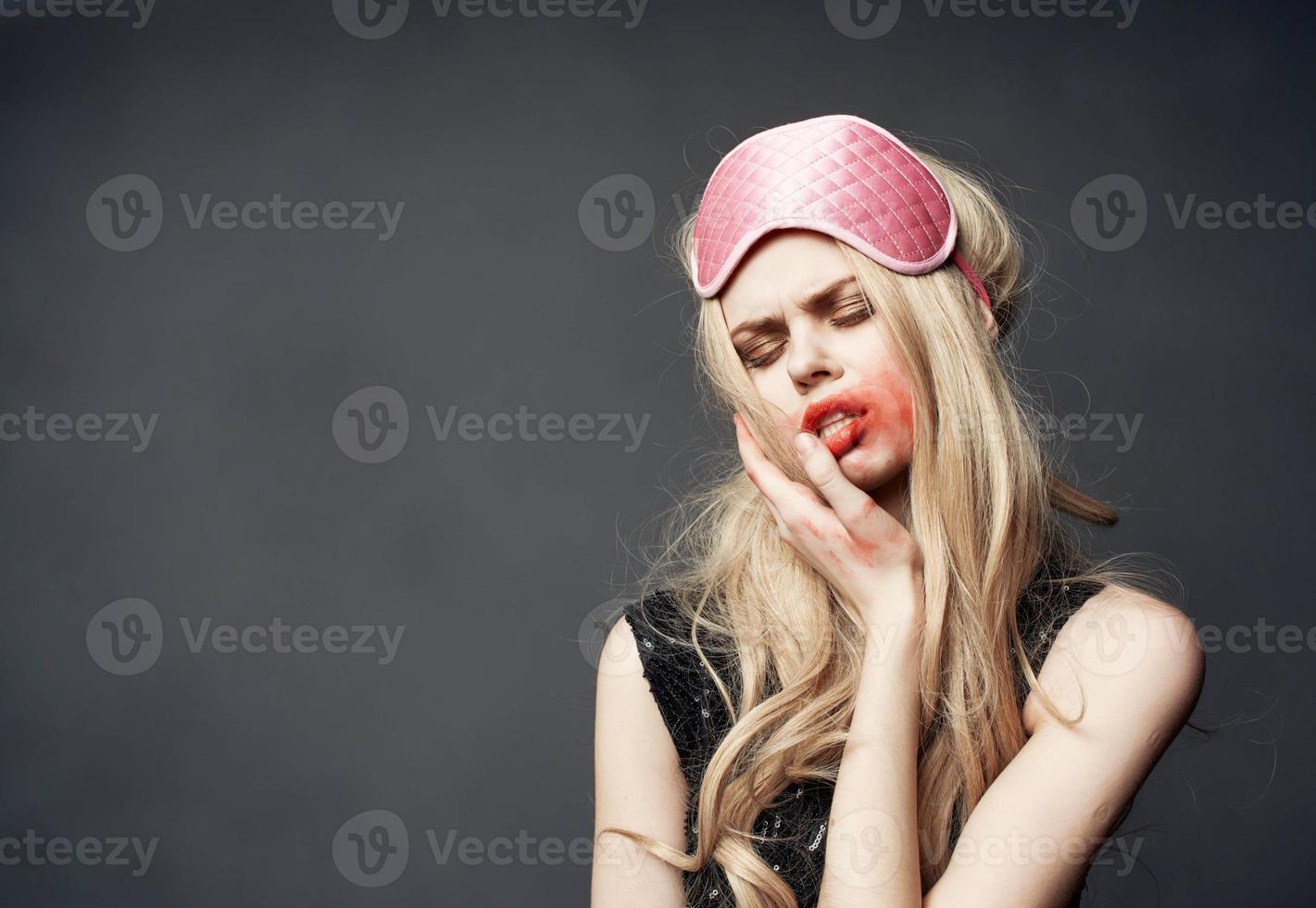 dronken blond met roze slaap masker uitstrijkjes lippenstift allemaal over- haar gezicht foto