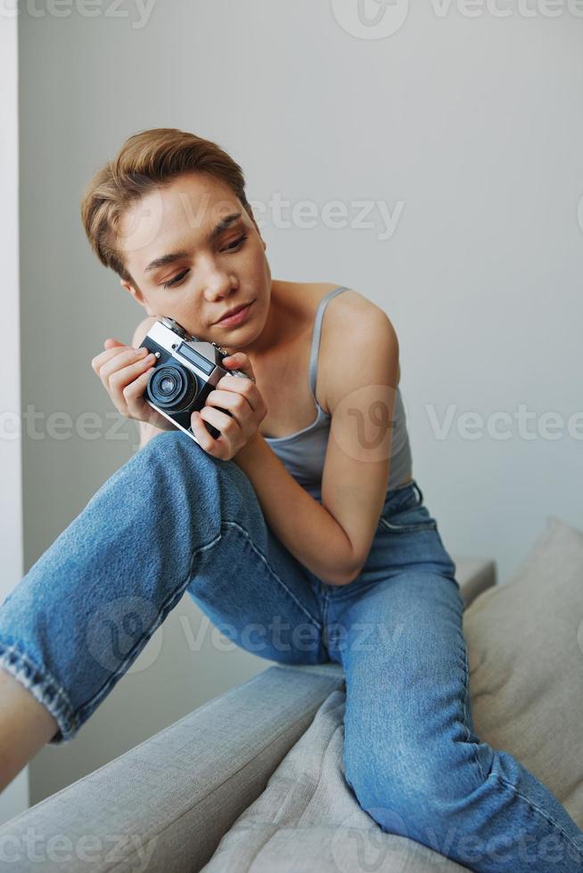 vrouw fotograaf het schieten in studio Aan oud film camera Bij huis Aan bankstel portret, wit achtergrond, vrij kopiëren ruimte, freelance fotograaf foto