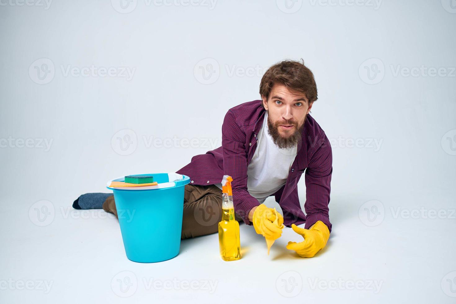 een Mens leugens Aan de verdieping met een emmer van wasmiddel schoonmaak onderhoud licht achtergrond foto