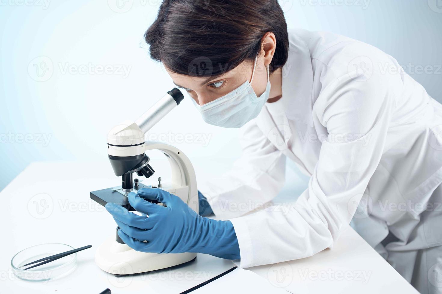 vrouw laboratorium assistent medisch masker microscoop diagnostiek biotechnologie foto