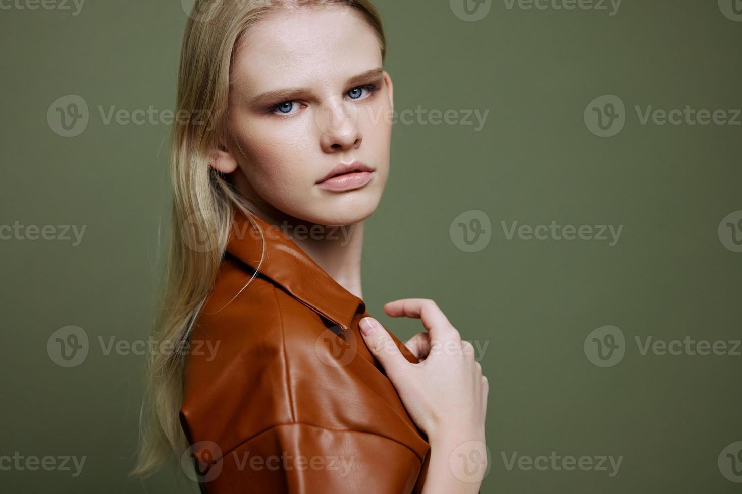 mode aanbod voor banier ontwerp. detailopname portret van zelfverzekerd jong vrouw aanraken leer loopgraaf jas looks Bij camera Bij olijf- groen studio muur achtergrond foto