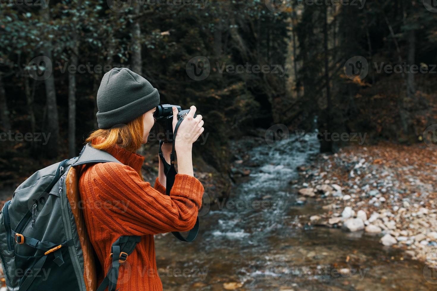 vrouw met een camera Aan natuur in de bergen in de buurt de rivier- kant visie foto