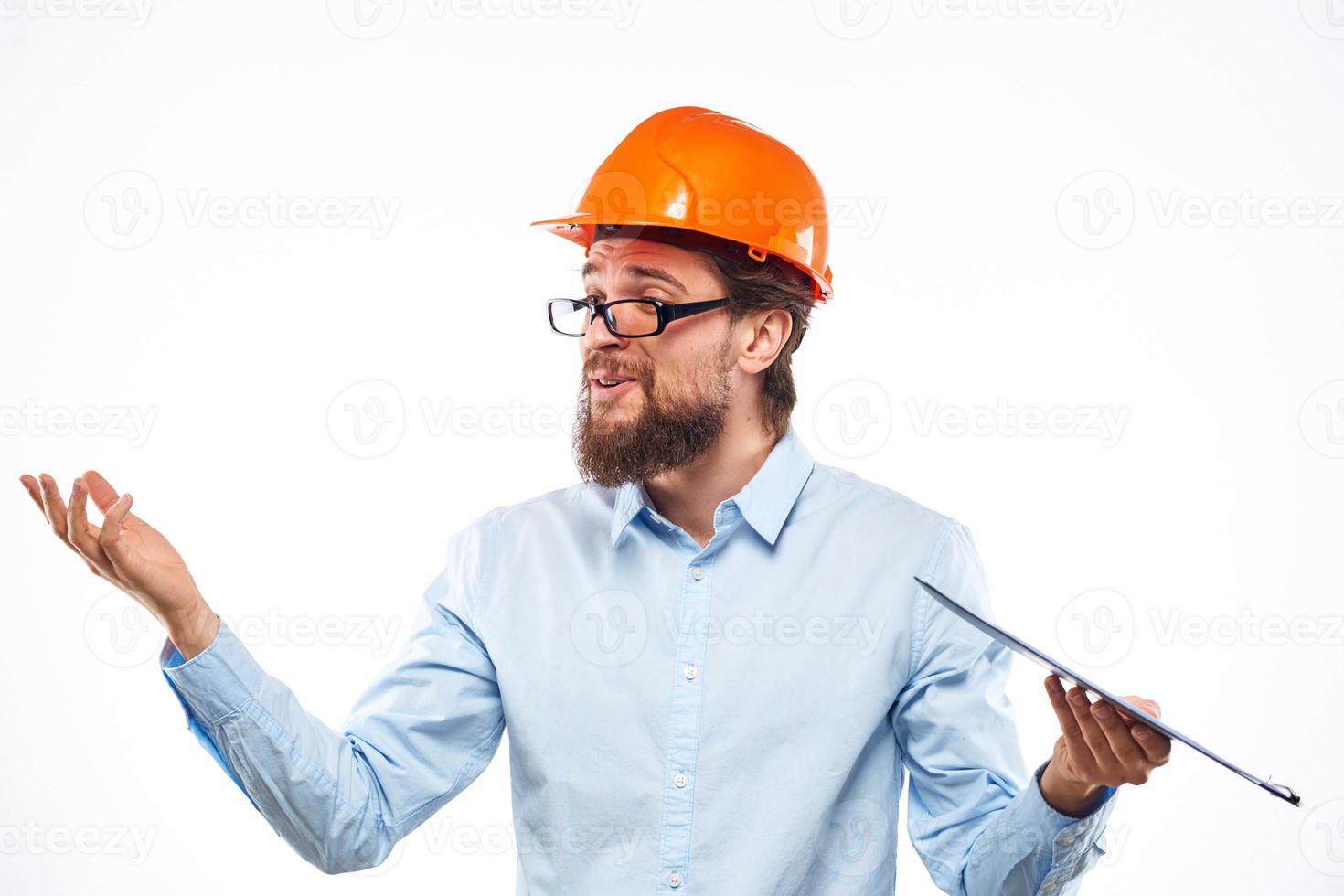 vrolijk Mens in oranje moeilijk hoed bouw documenten onderhoud professionals foto