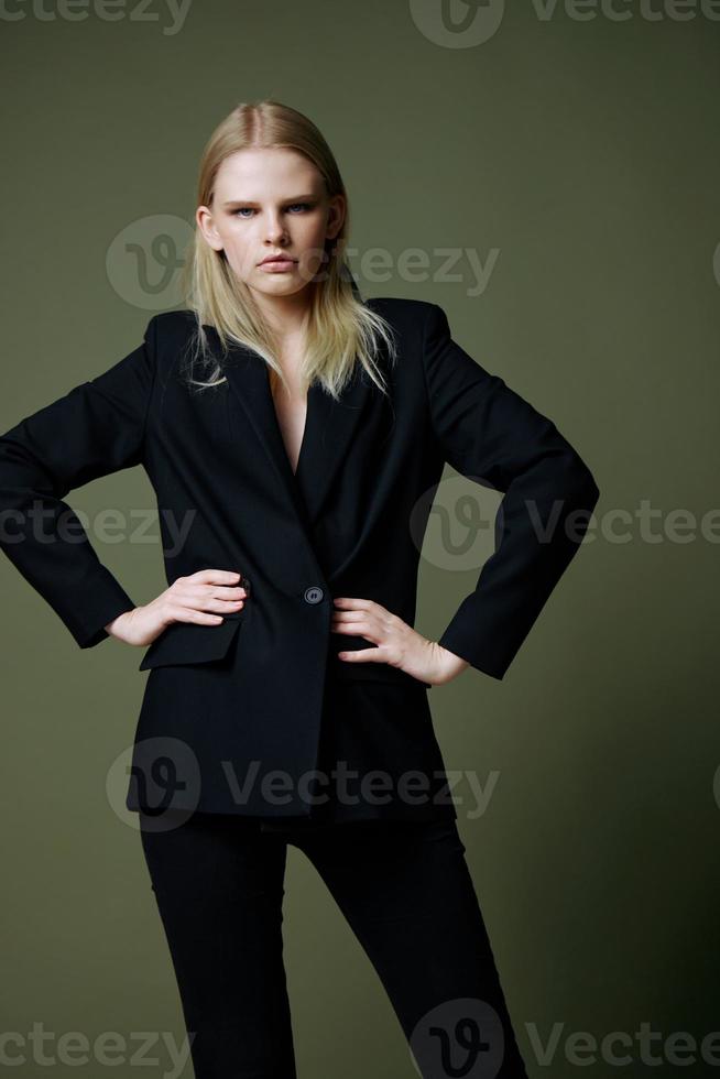 de meisje houdt beide handen Aan haar taille poseren Aan een groen achtergrond in de studio. concept voor kleding merken foto