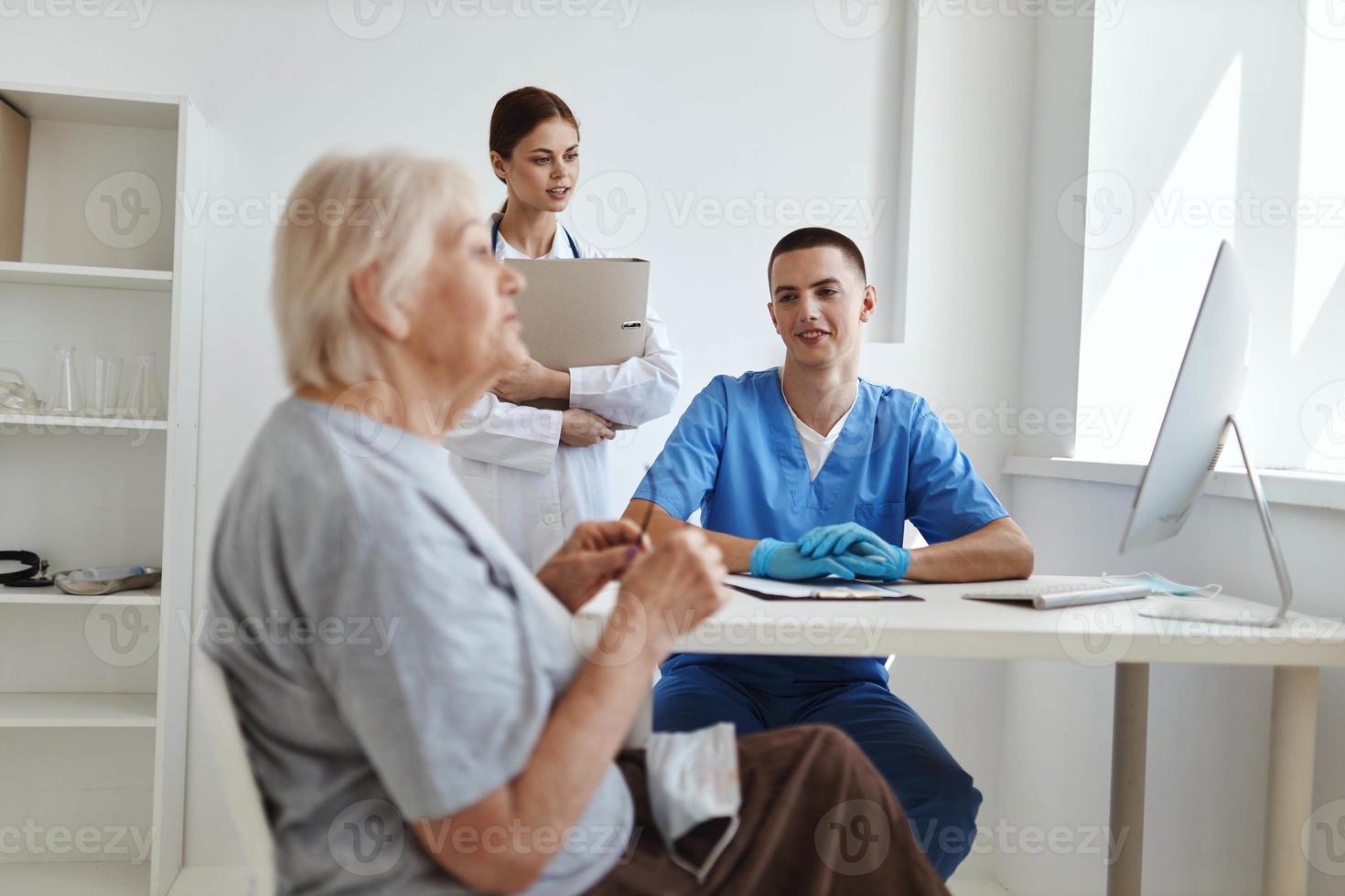 vrouw geduldig communiceert met dokter en verpleegster assistent foto