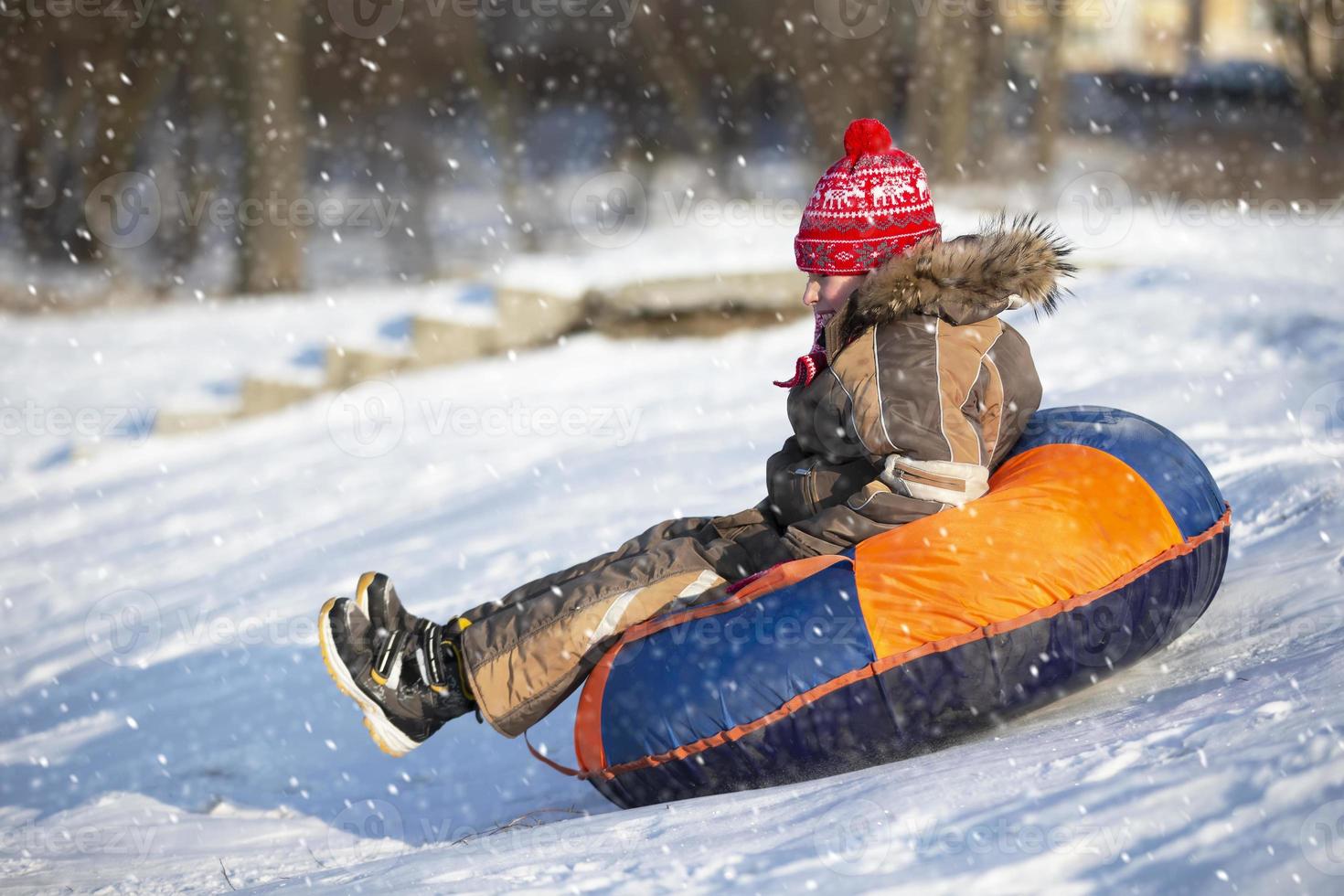 weinig kind Aan een slee. kind Aan een winter dag. een jongen is rijden Aan een sneeuw schuiven. foto