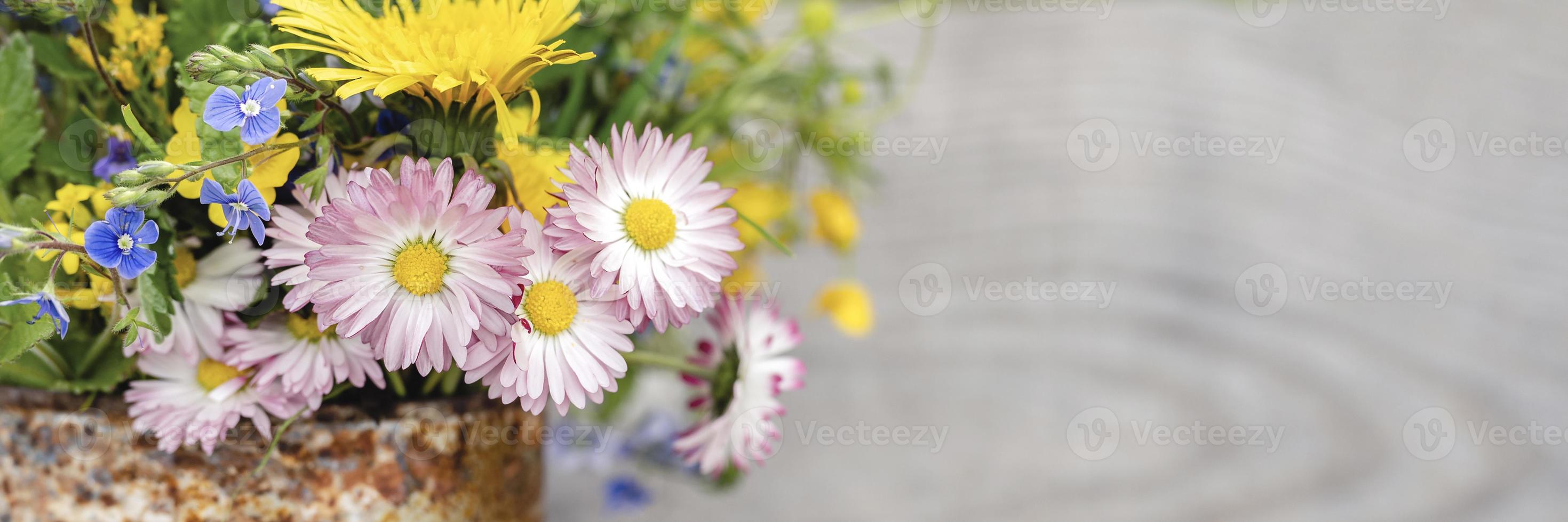 een boeket wilde bloemen van vergeet-mij-nietjes, madeliefjes en gele paardebloemen in volle bloei in een rustieke pot foto