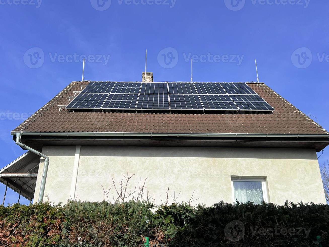 huis zonne- paneel. alternatief energie is gebruikt voor verwarming en water verwarming. milieuvriendelijk alternatief energie voor huis. woon- familie huis voorstad. bruin tegel dak van huis met zonne- panelen. foto