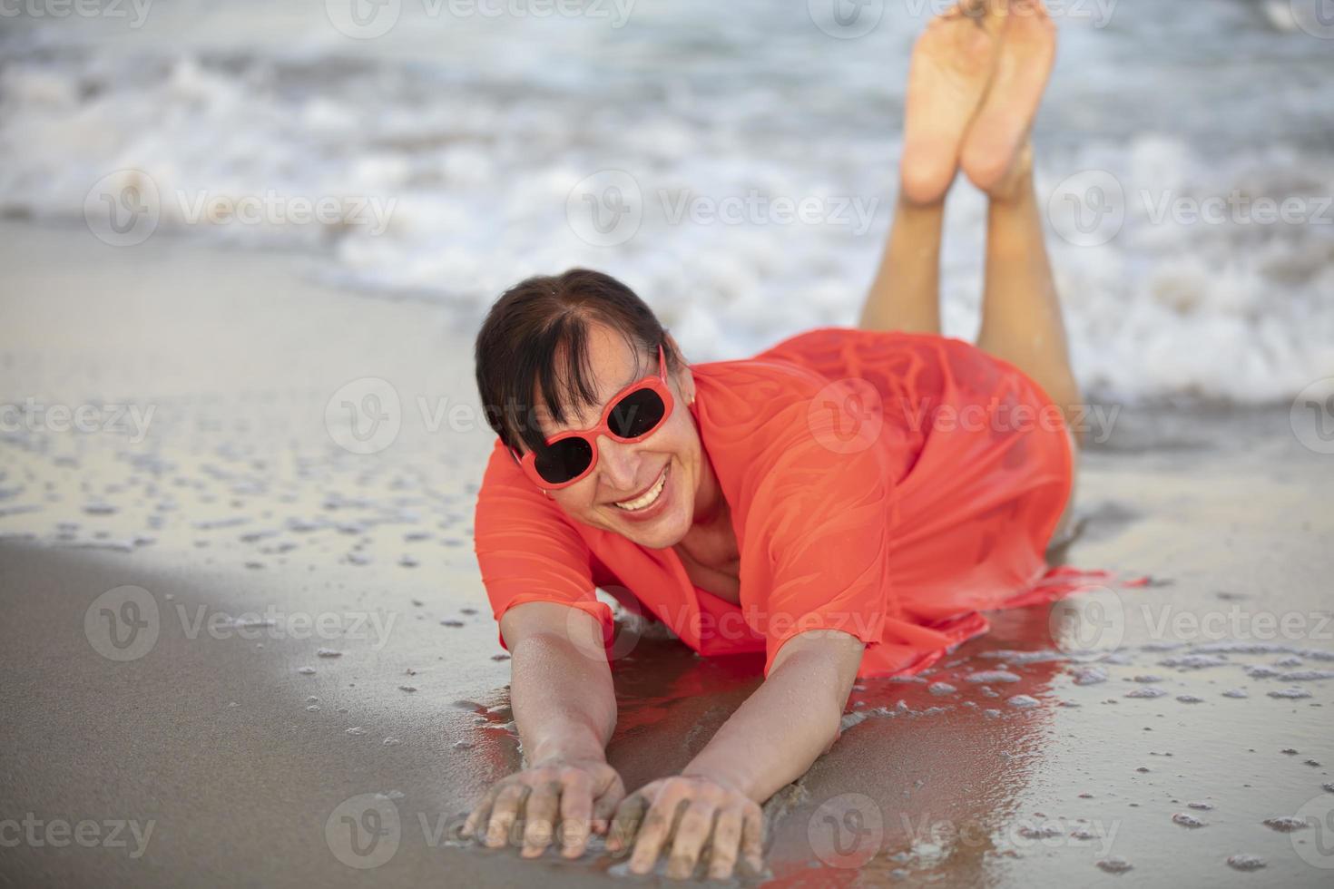 gelukkig vrouw Bij de zee..portret van een senior vrouw het baden in de zee foto
