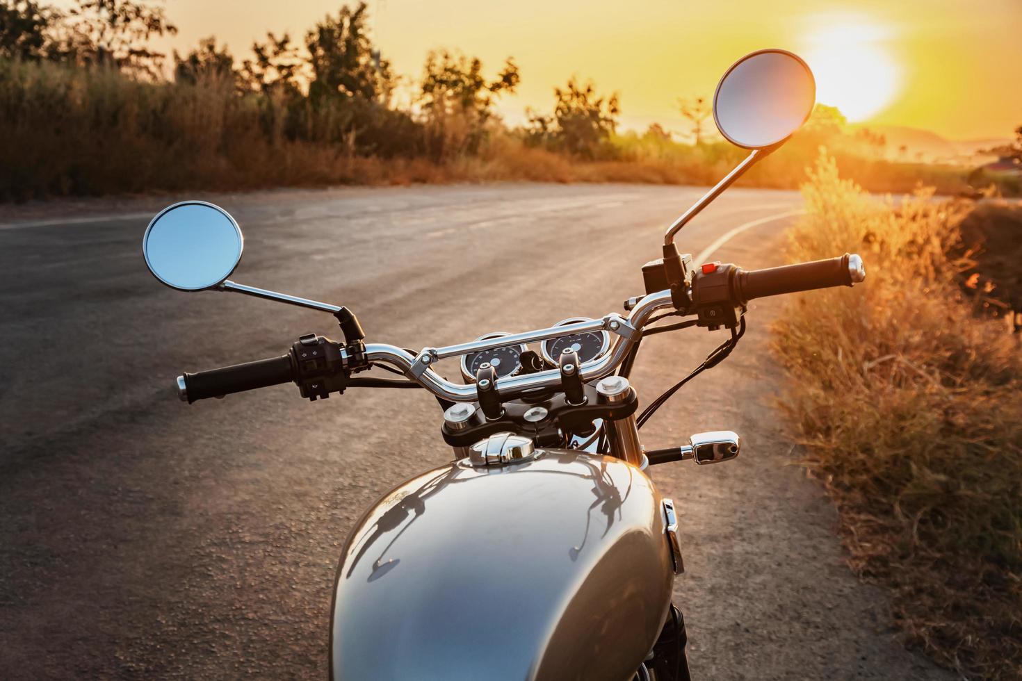 klassiek stijl motorfiets Aan weg met zonsondergang foto