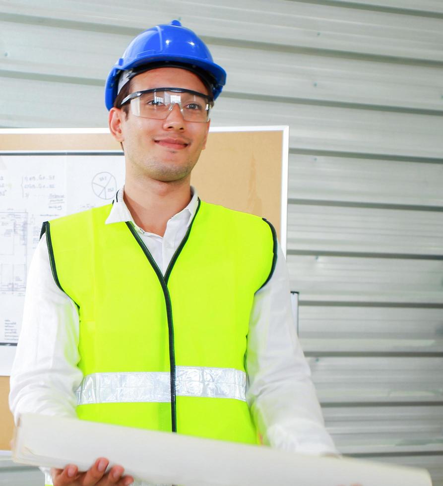 jonge ingenieur permanent met een laptop op een bouwplaats foto