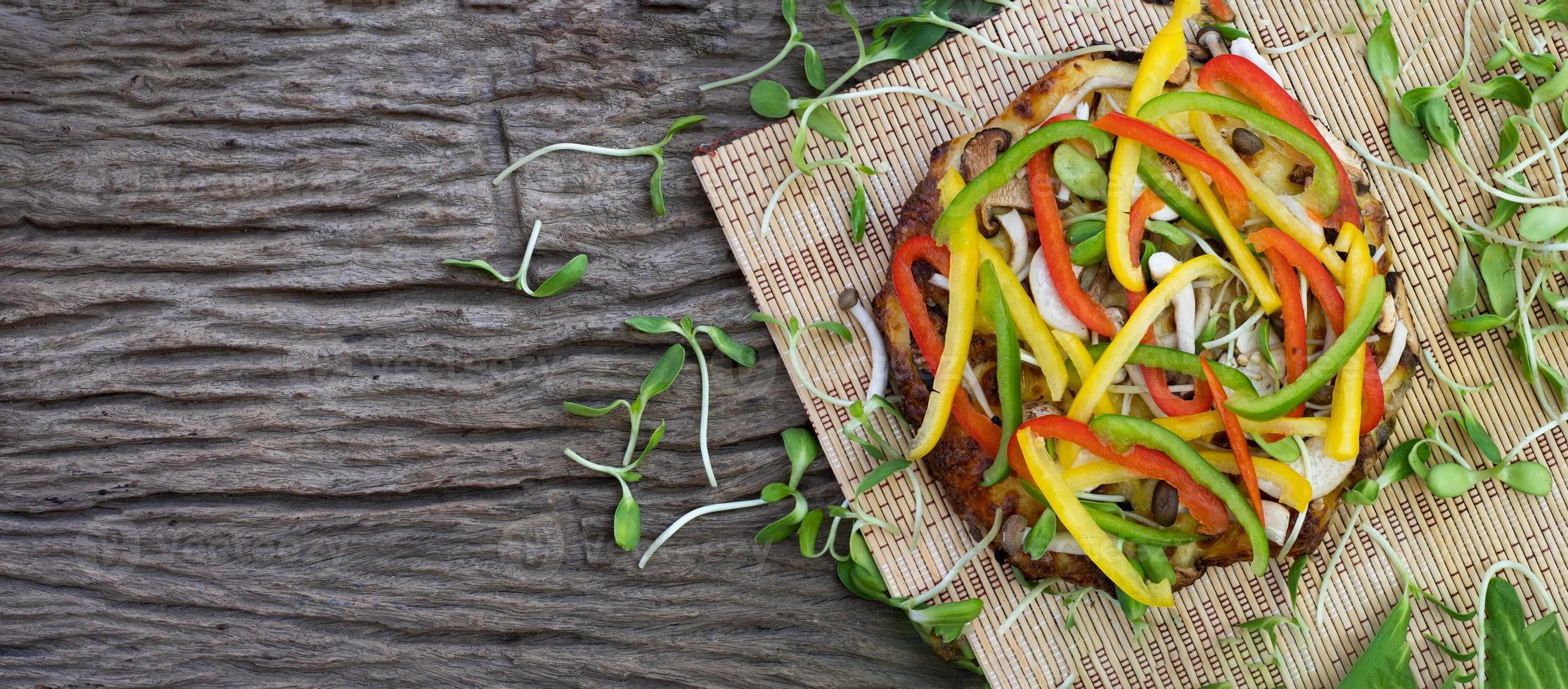 zelfgemaakte plantaardige pizza met zonnebloem spruiten op een houten tafel achtergrond foto