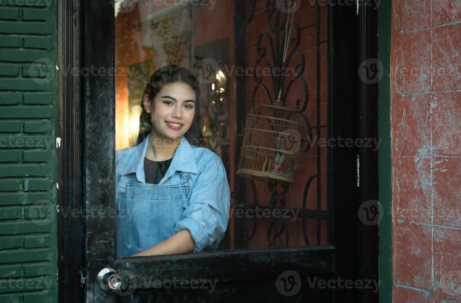 een jong zakenvrouw wie bezit een pottenbakkerij school- Open de deur naar Welkom studenten wie liefde naar leren pottenbakkerij. foto