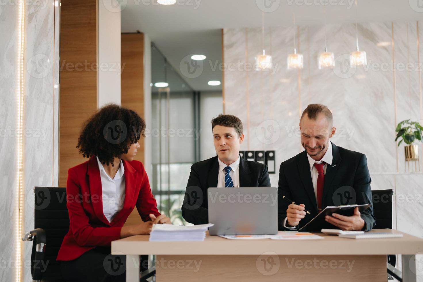 gelukkig mensen uit het bedrijfsleven terwijl samenwerken Aan een nieuw project in een kantoor. groep van verschillend mensen uit het bedrijfsleven gebruik makend van een laptop en tablet in kantoor. foto