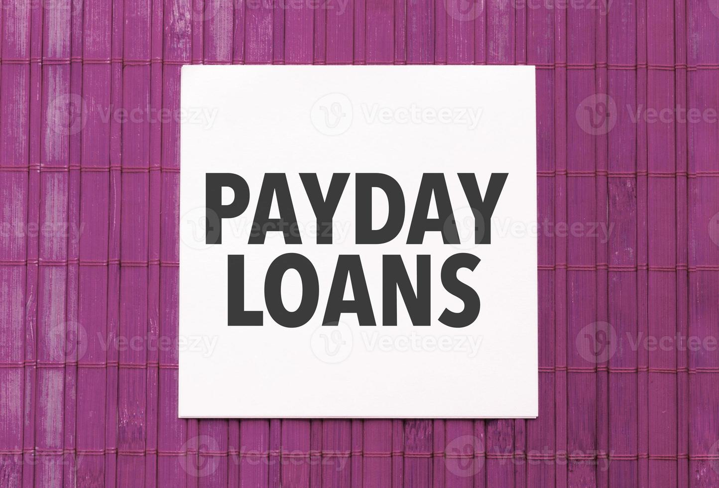 wit sticker met tekst betaaldag leningen Aan roze houten achtergrond foto