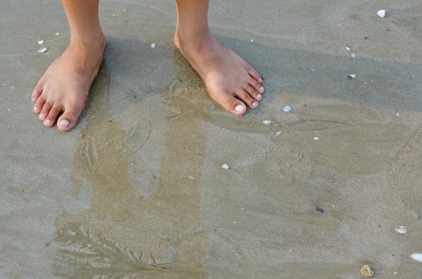 voeten staand Aan zand strand concept achtergrond foto