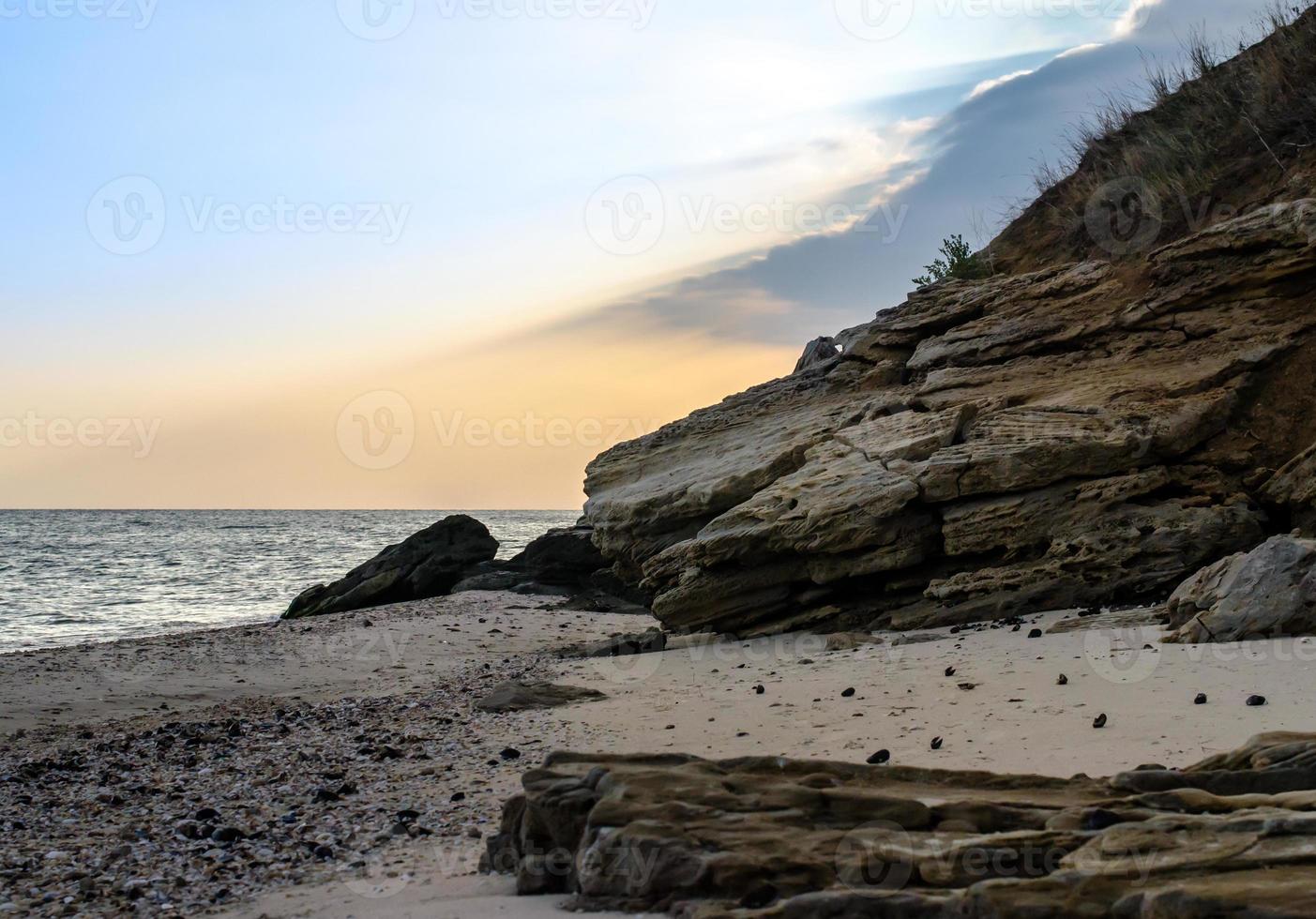 rotsachtige kust tegen de avondlucht foto