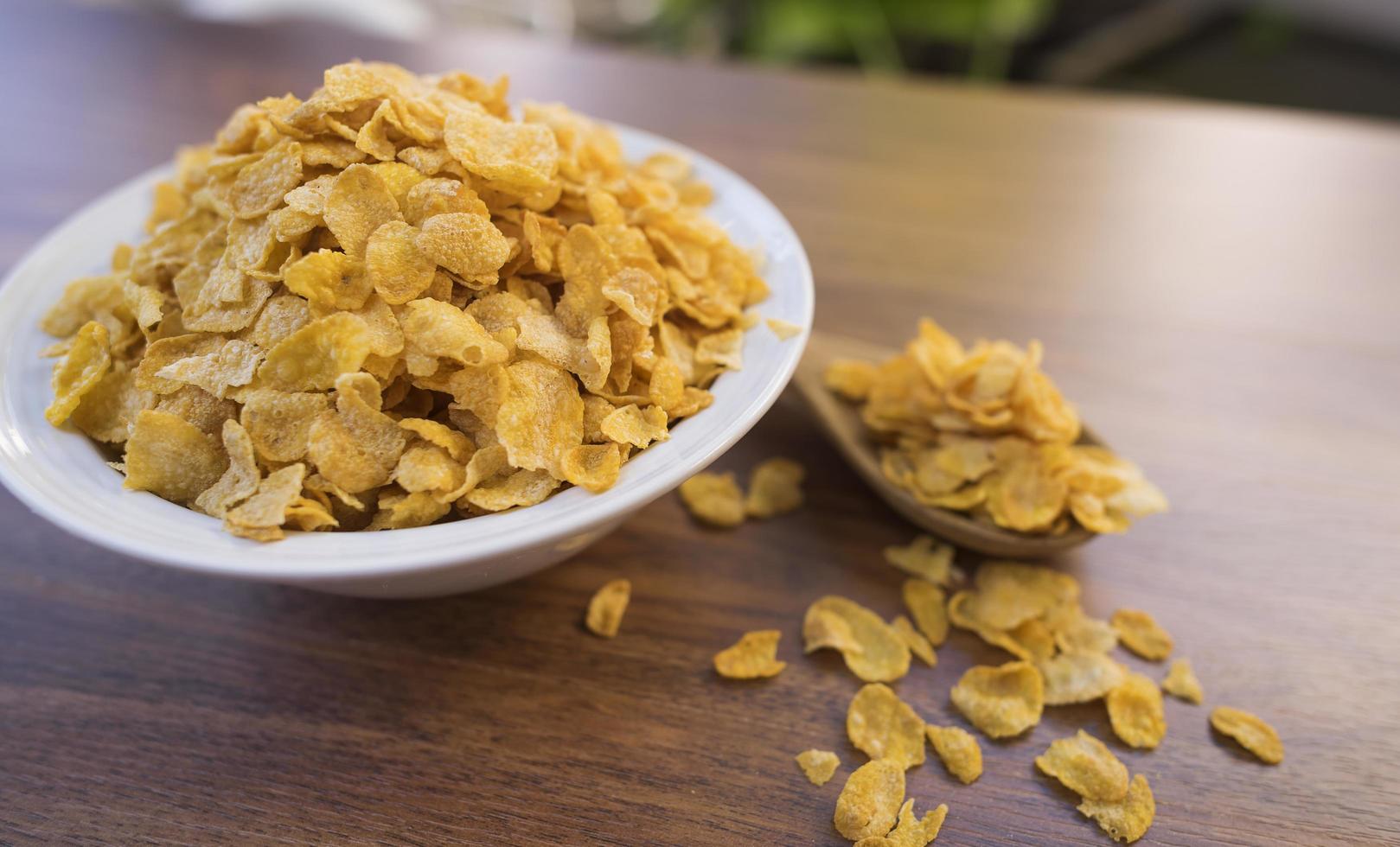 cornflakes en kom op houten tafel foto