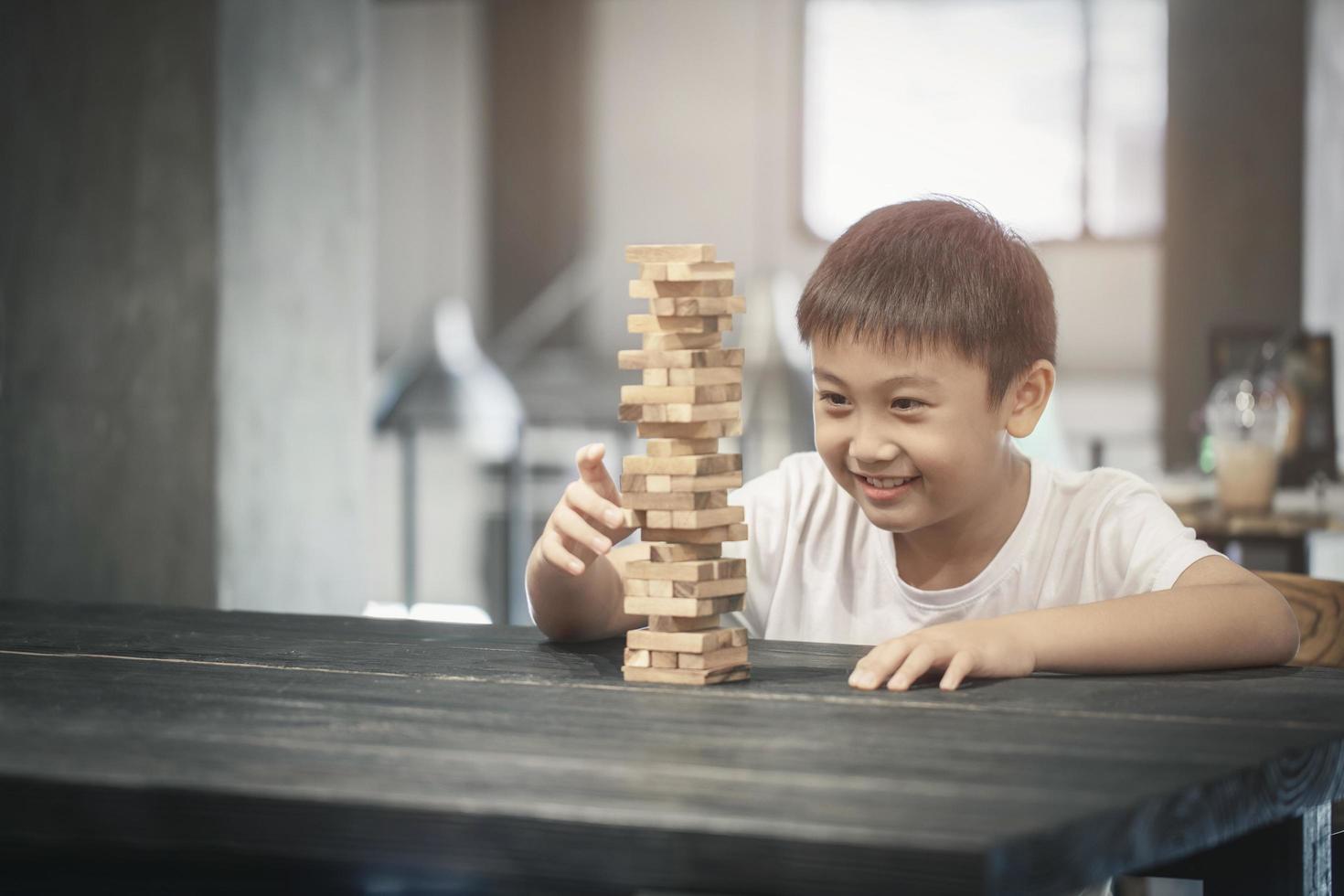 jongen die een houten blokspel speelt foto