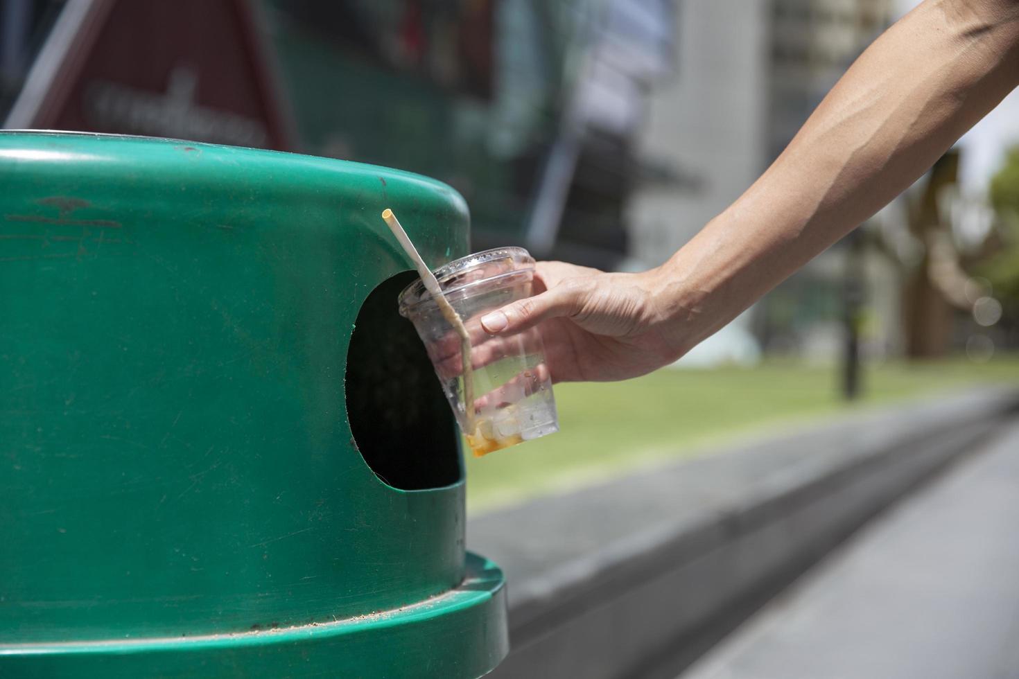 persoon die een plastic beker recyclet foto