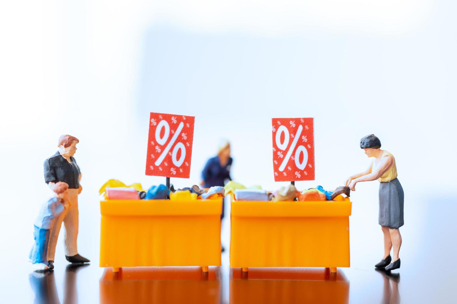 miniatuur shoppers met een voordeelbakje voor het kopen van afgeprijsde artikelen foto