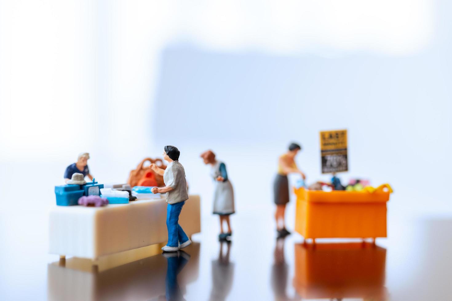 miniatuur shoppers met een voordeelbakje voor het kopen van afgeprijsde artikelen foto