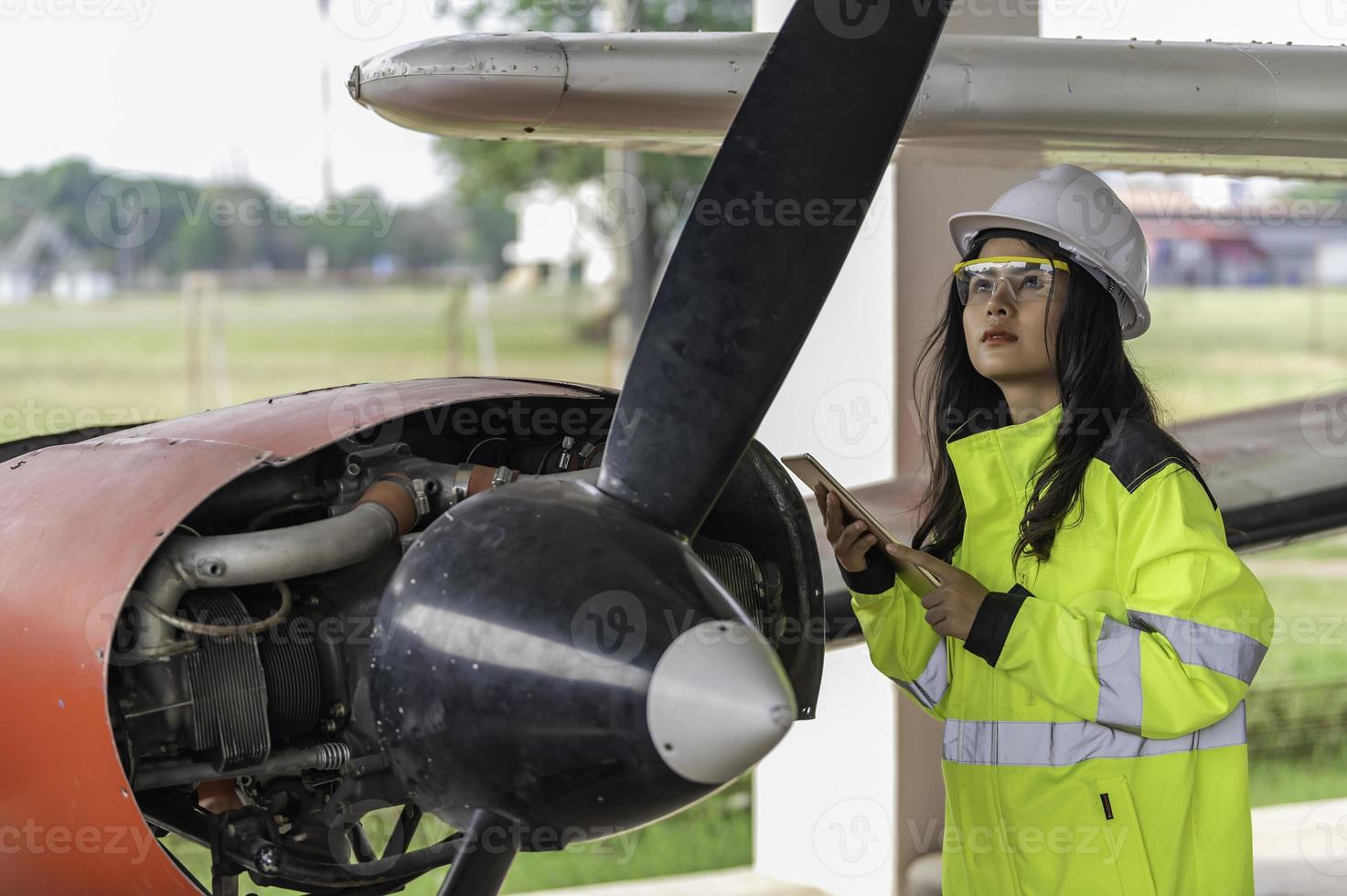 technicus die de motor van het vliegtuig repareert, vrouwelijke lucht- en ruimtevaarttechniek die vliegtuigmotoren controleert, aziatisch monteur onderhoud inspecteert vliegtuigmotor; foto