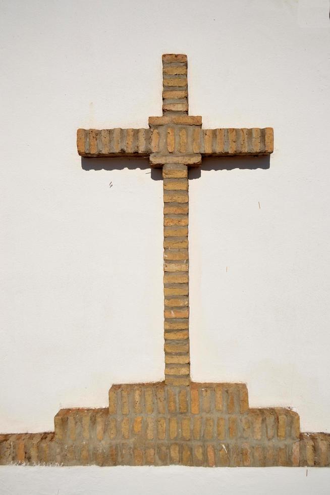 christelijk kruis van bakstenen op een witte achtergrond foto