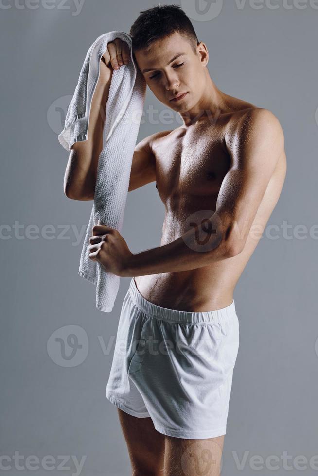 Mens met een handdoek in zijn handen doekjes zweet van zijn gezicht in wit shorts geïsoleerd achtergrond foto