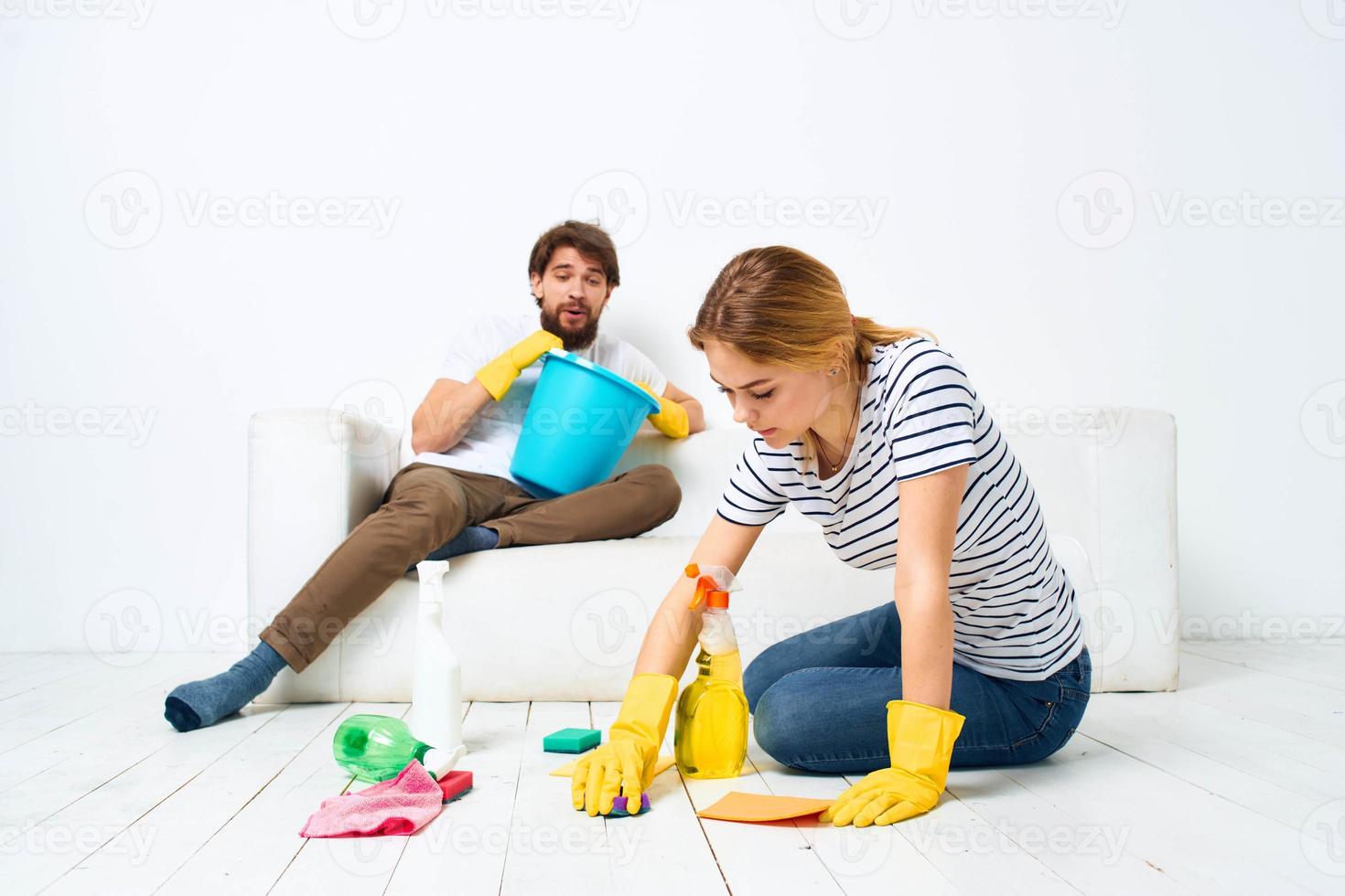 jong paar zijn aan het doen schoonmaak samen in de kamer licht achtergrond foto