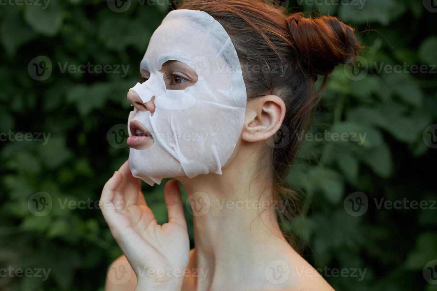 mooi vrouw wit masker verrast kijken emoties huid zorg bladeren in de achtergrond foto