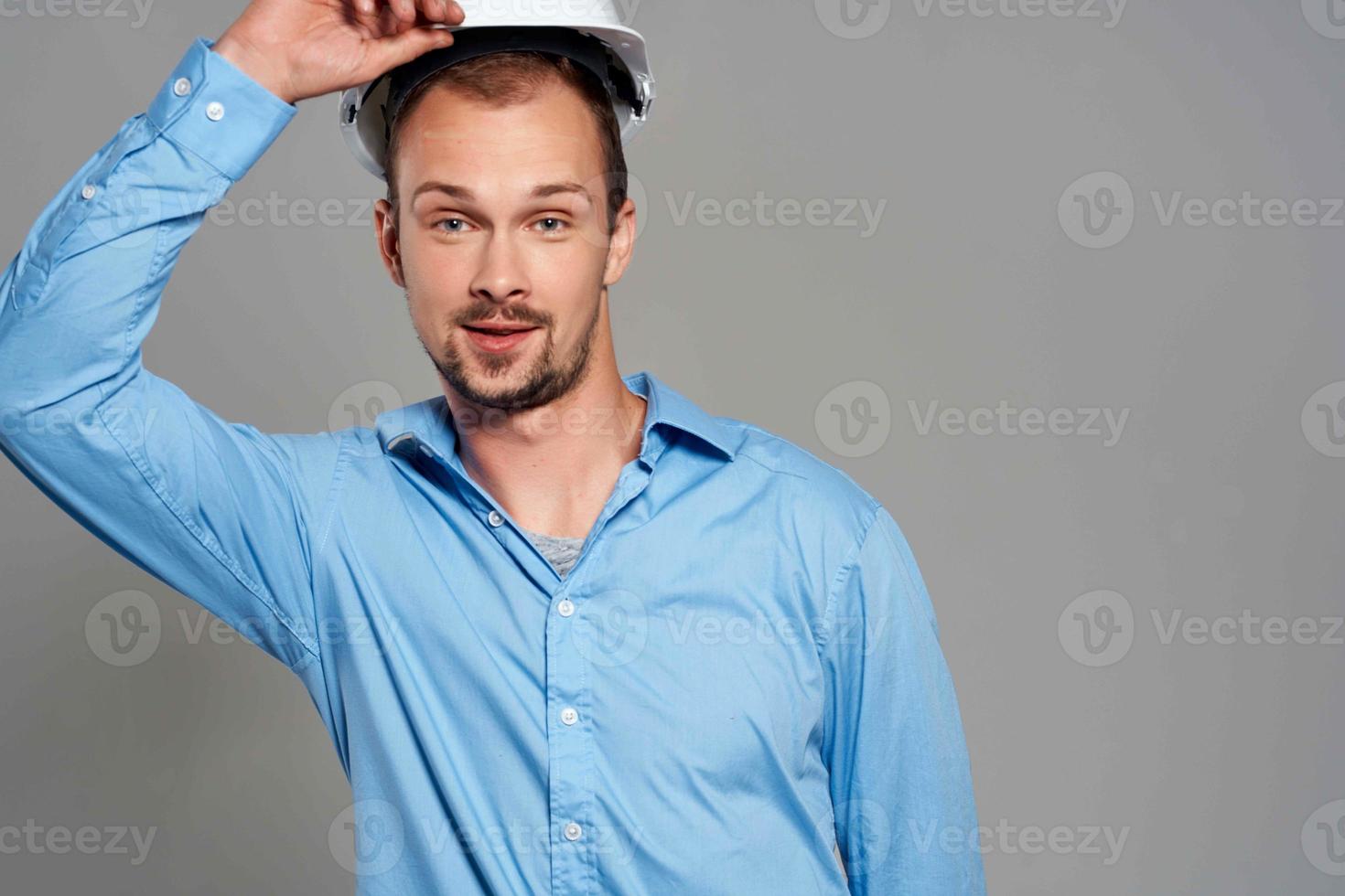 Mens in blauw overhemd ingenieur bouw helm veiligheid werk foto